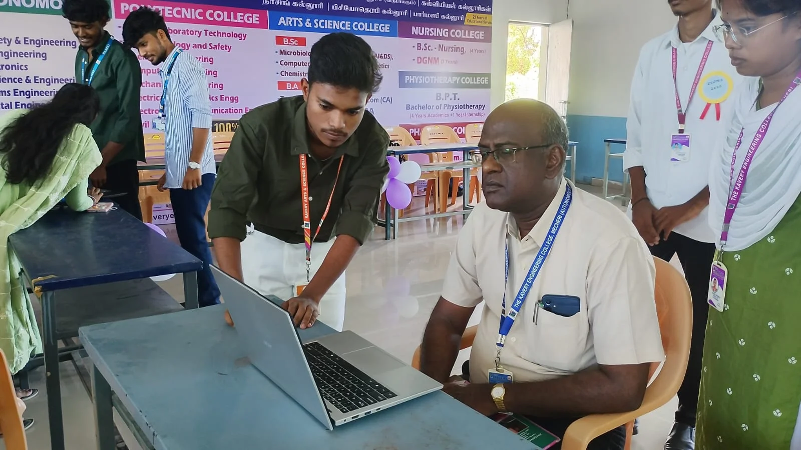 Mano showing a working project on a laptop at a college expo